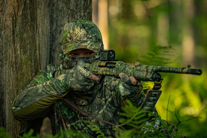 camouflaged man aiming gun