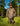Person wearing men's camo sweatshirt and pants standing in forest clearing under bright sunlight.