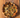 Wood-fired wild turkey sausage pizza with melted cheese and peppers on a rustic wooden board.