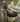 Camouflage hunting glove with 'Noma' branding on a blurred natural background